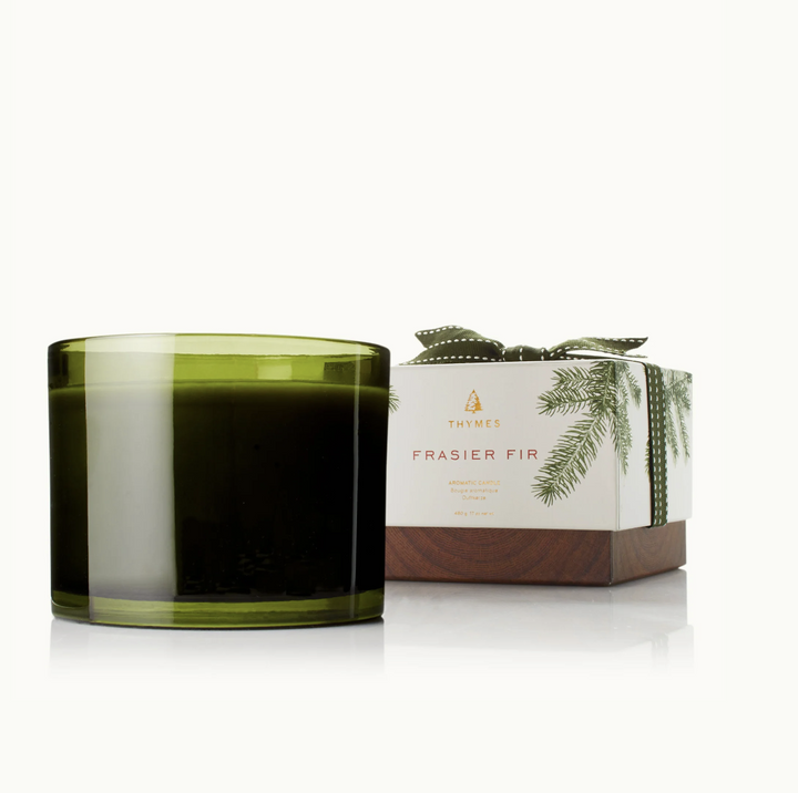 Green candle with a box labeled 'Frasier Fir' on a white background