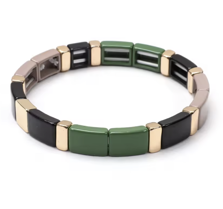 Bracelet with green, black, and gold square beads on a white background