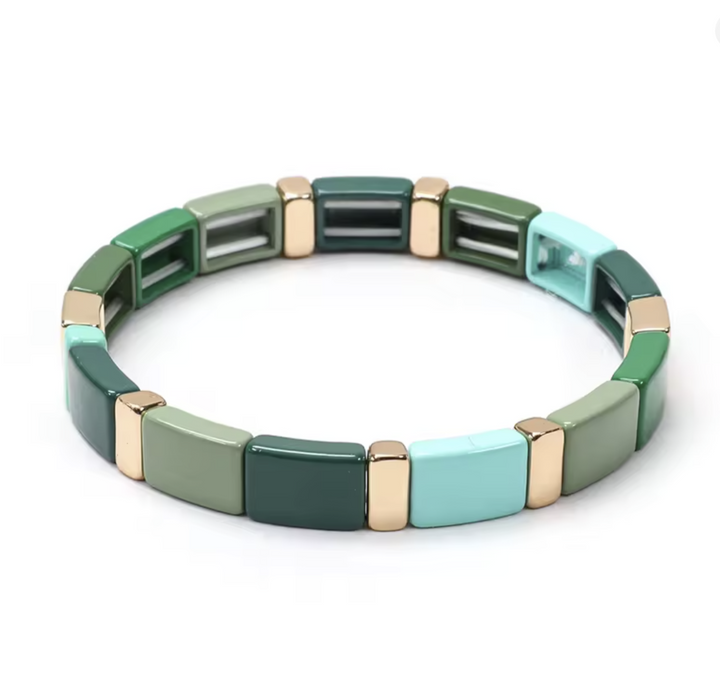 Multicolored bracelet with green, blue, and gold square beads on a white background