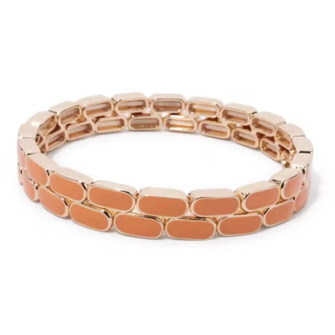 Rose gold bracelet with orange accents on a white background