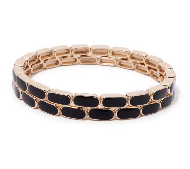 Gold bracelet with black oval links on a white background