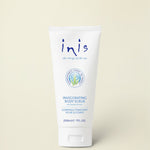 A white squeeze tube of Inis Invigorating Body Scrub with blue text, centered on a warm cream background.