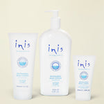 Three white Inis Revitalising Body Lotion containers on a light blue background: a 200ml squeeze tube, a 120ml pump bottle, and a 8ml travel tube, with a small silver foil pack at the lower left.