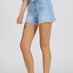 Person wearing light blue denim shorts on a plain background