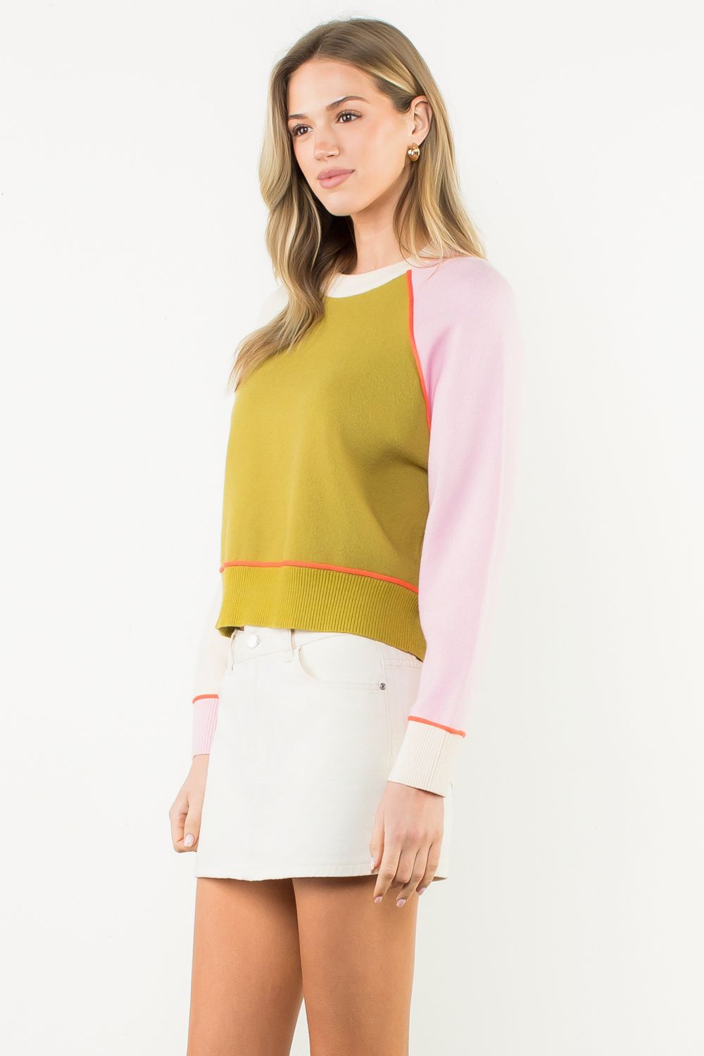 Lindsey Sweater - Woman wearing a colorful sweater with pink sleeves and a green body on a white background