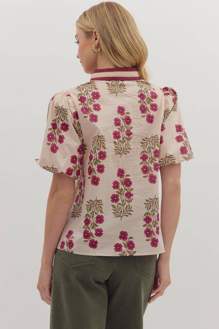 Woman wearing a floral blouse with a plain background