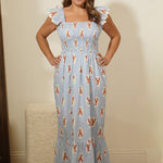 Woman wearing a blue dress with bear pattern against a plain background