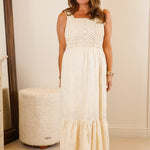 Woman in a white dress standing in a bedroom