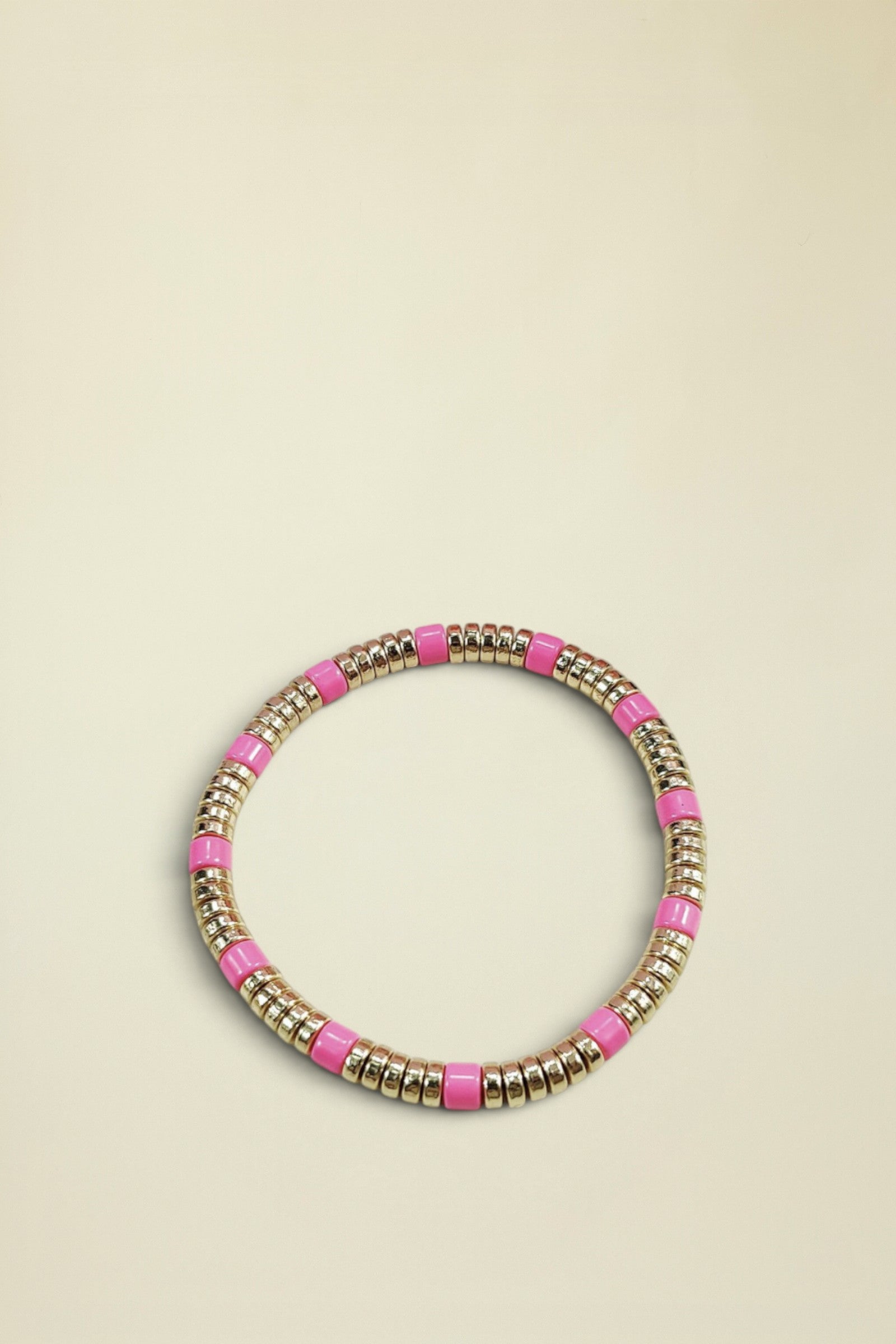 Bracelet with pink and gold beads on a white background