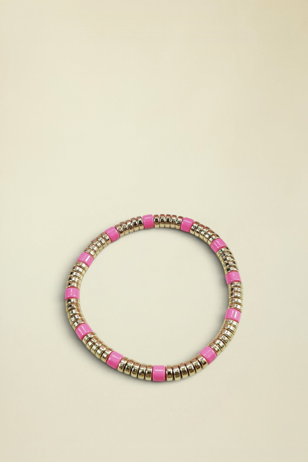 Bracelet with pink and gold beads on a white background