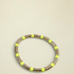 Neon yellow and gold beaded bracelet on a light gray background