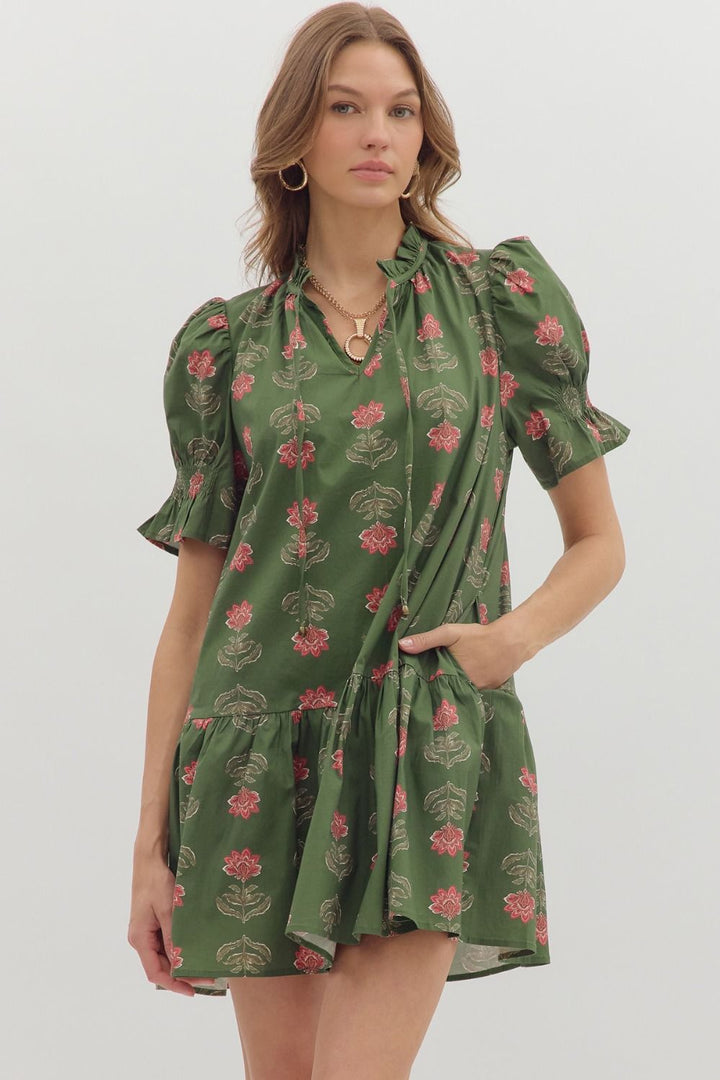 Woman wearing a green floral dress against a white background