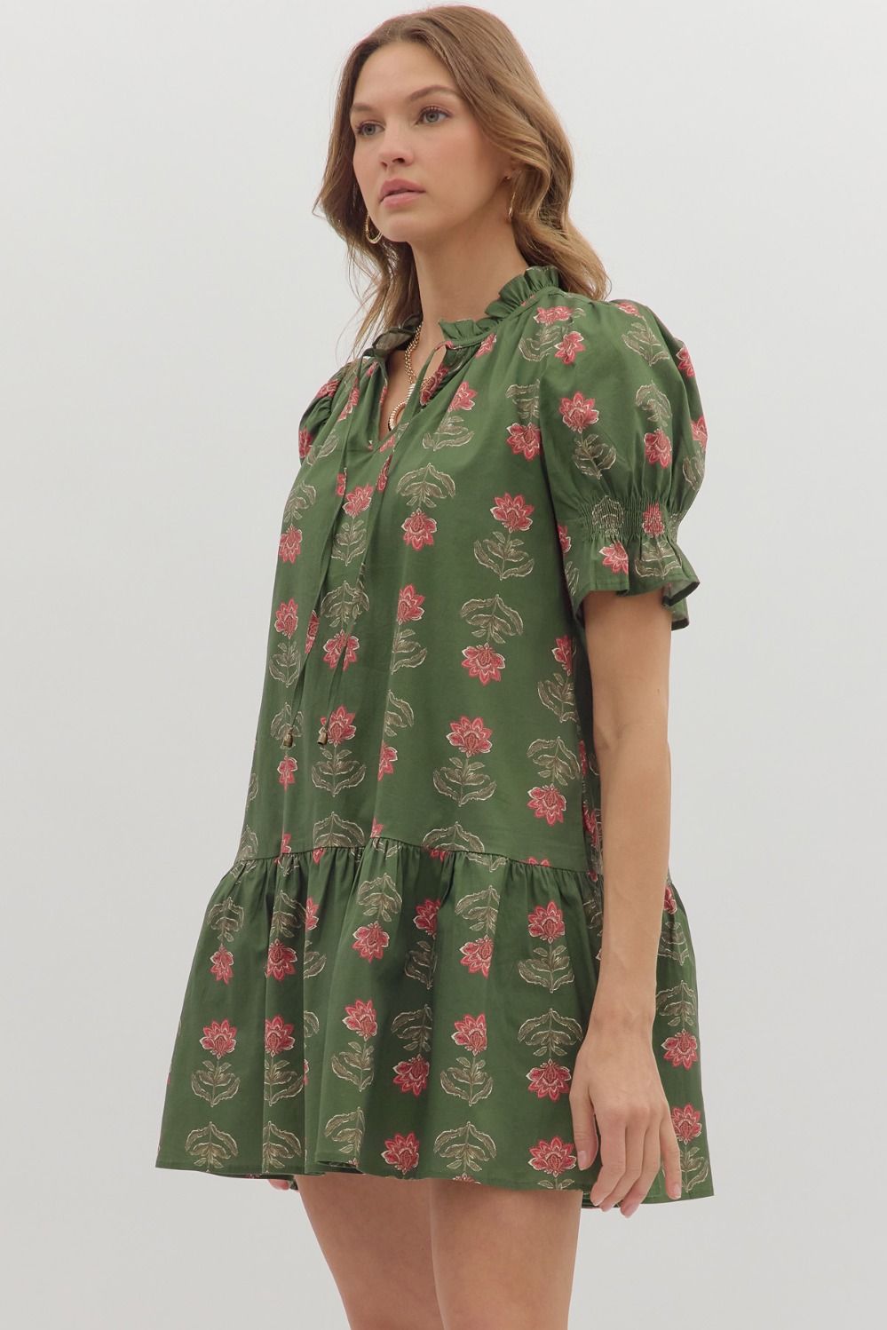 Woman wearing a green floral dress on a white background