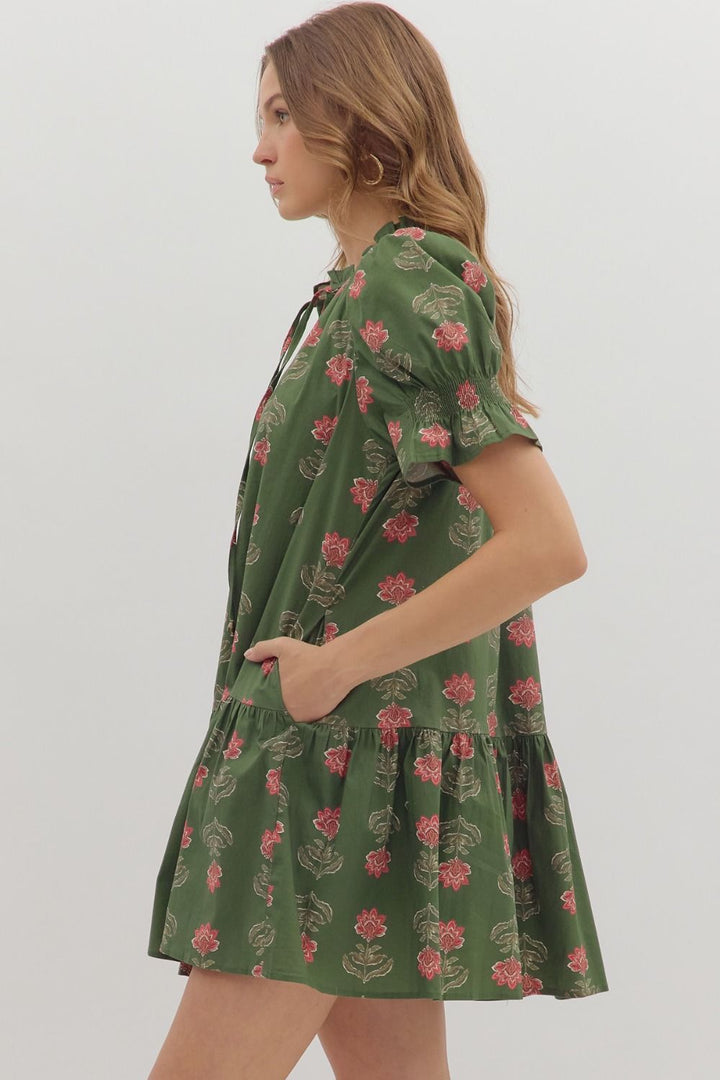 Woman wearing a green floral dress on a white background