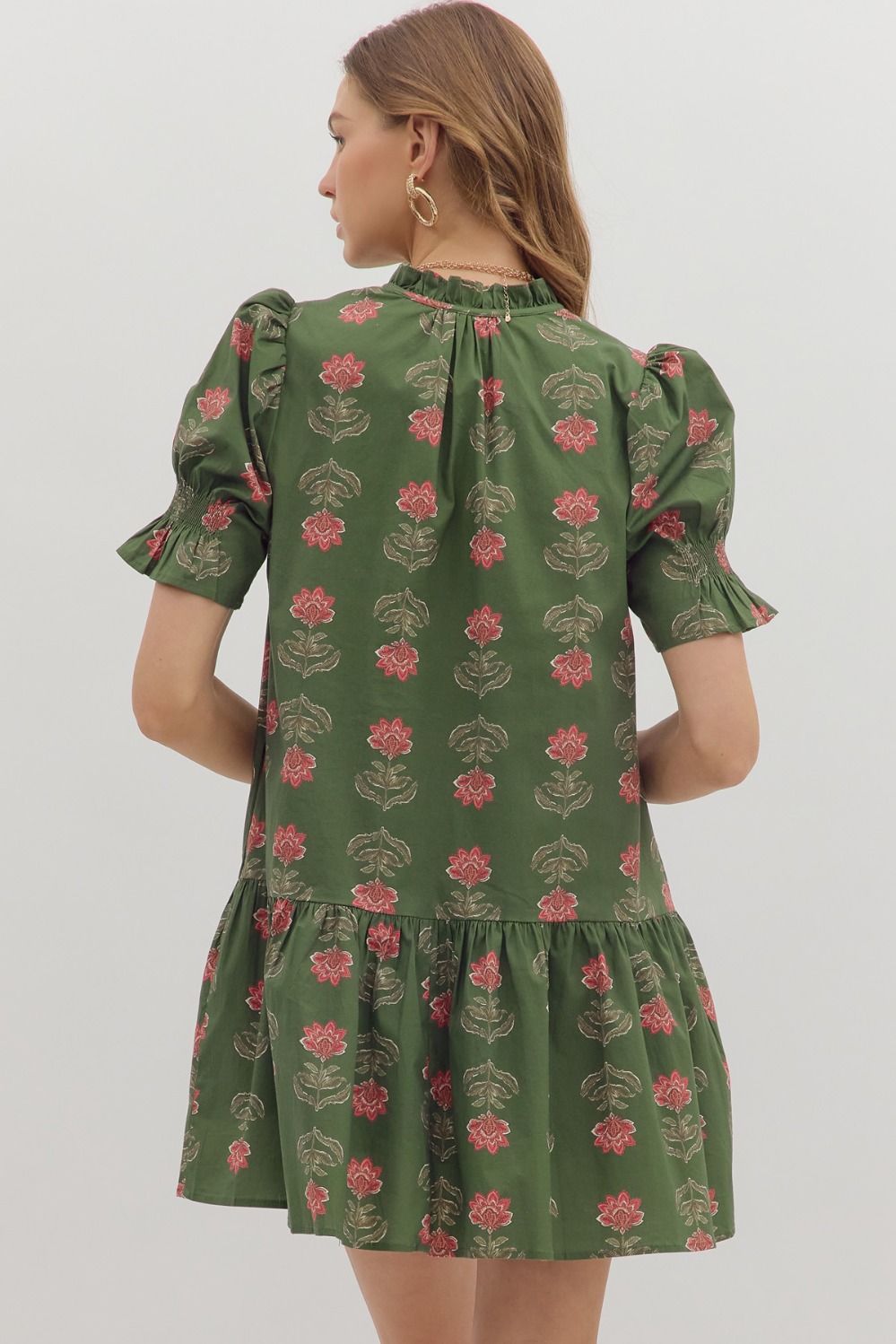 Green floral dress worn by a person on a white background