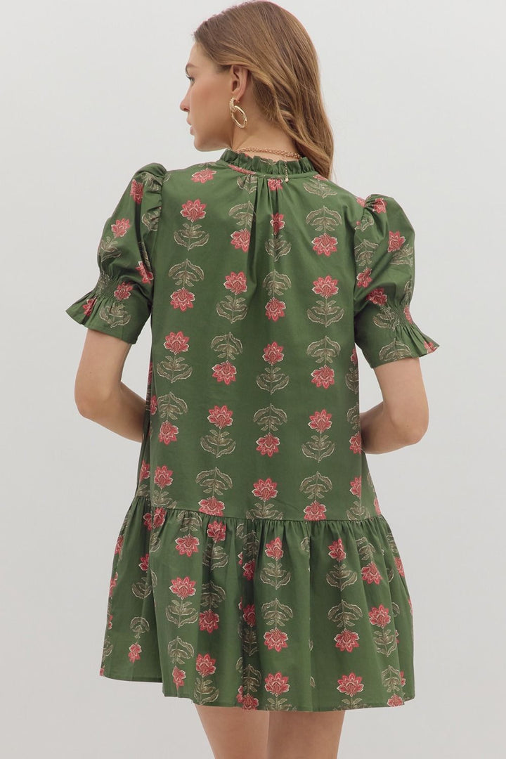Green floral dress worn by a person on a white background