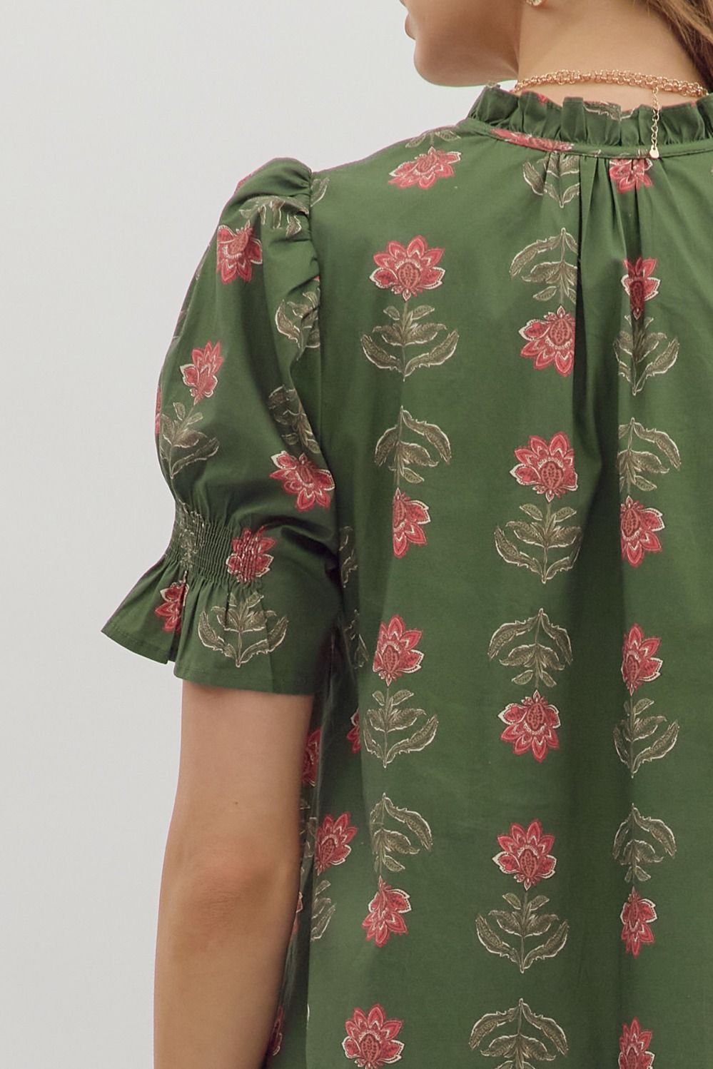 Green dress with floral pattern on a plain background