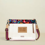 Point of Origin Consuela clear crossbody bag with colorful Sophie print trim, natural leather accents, and woven strap.