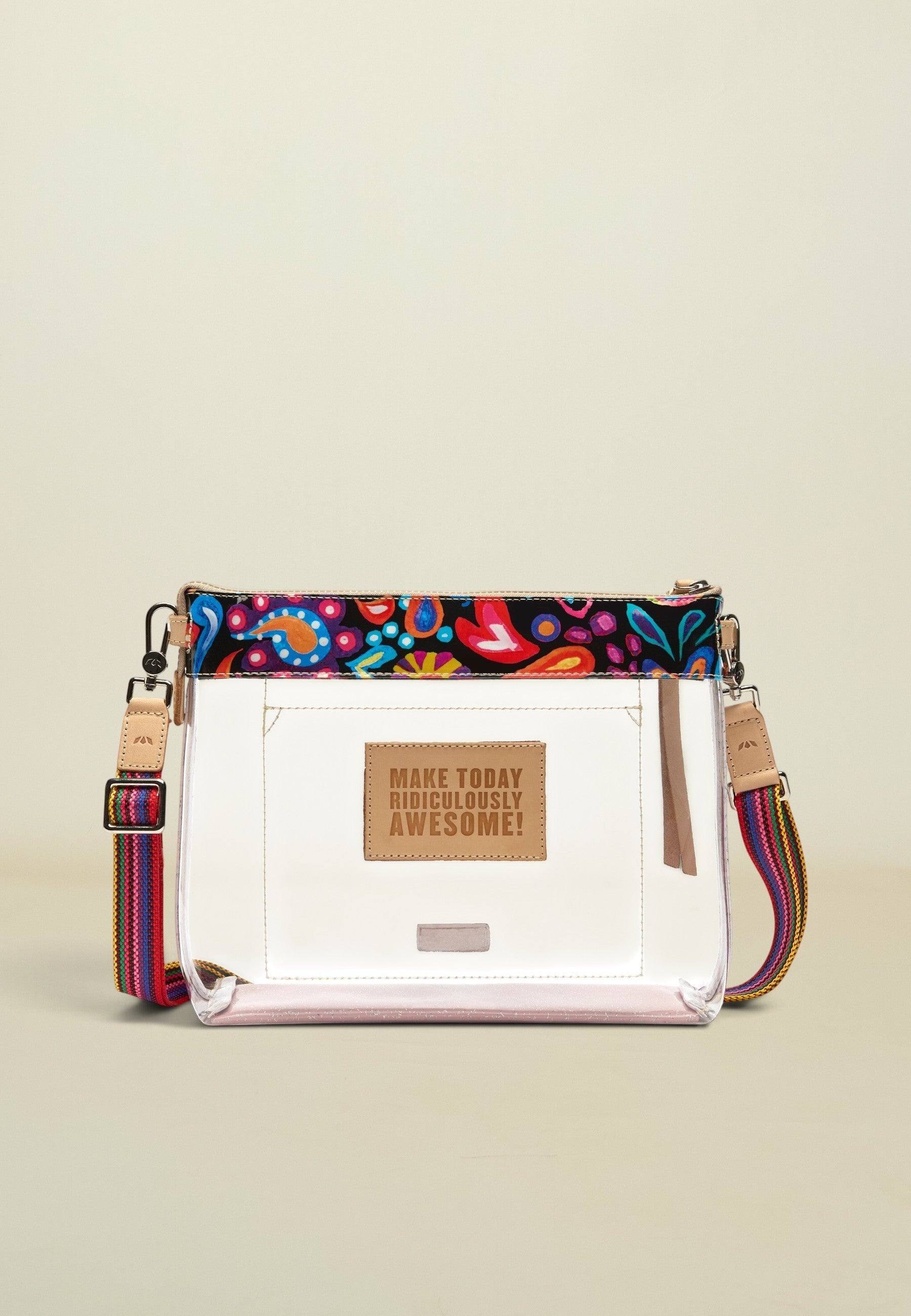 Point of Origin Consuela clear crossbody bag with colorful Sophie print trim, natural leather accents, and woven strap.