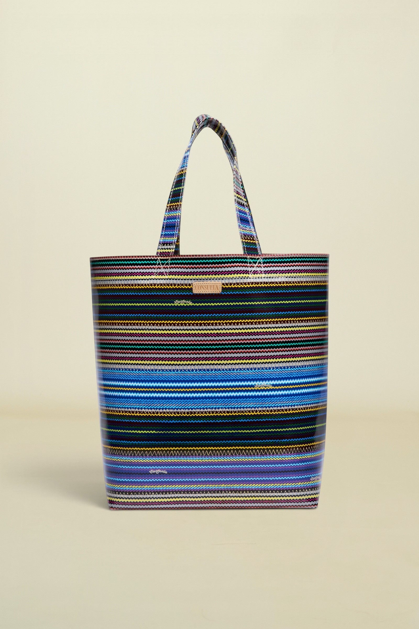 Point of Origin Consuela Hadley basic tote bag featuring a vibrant multi-colored horizontal striped pattern.