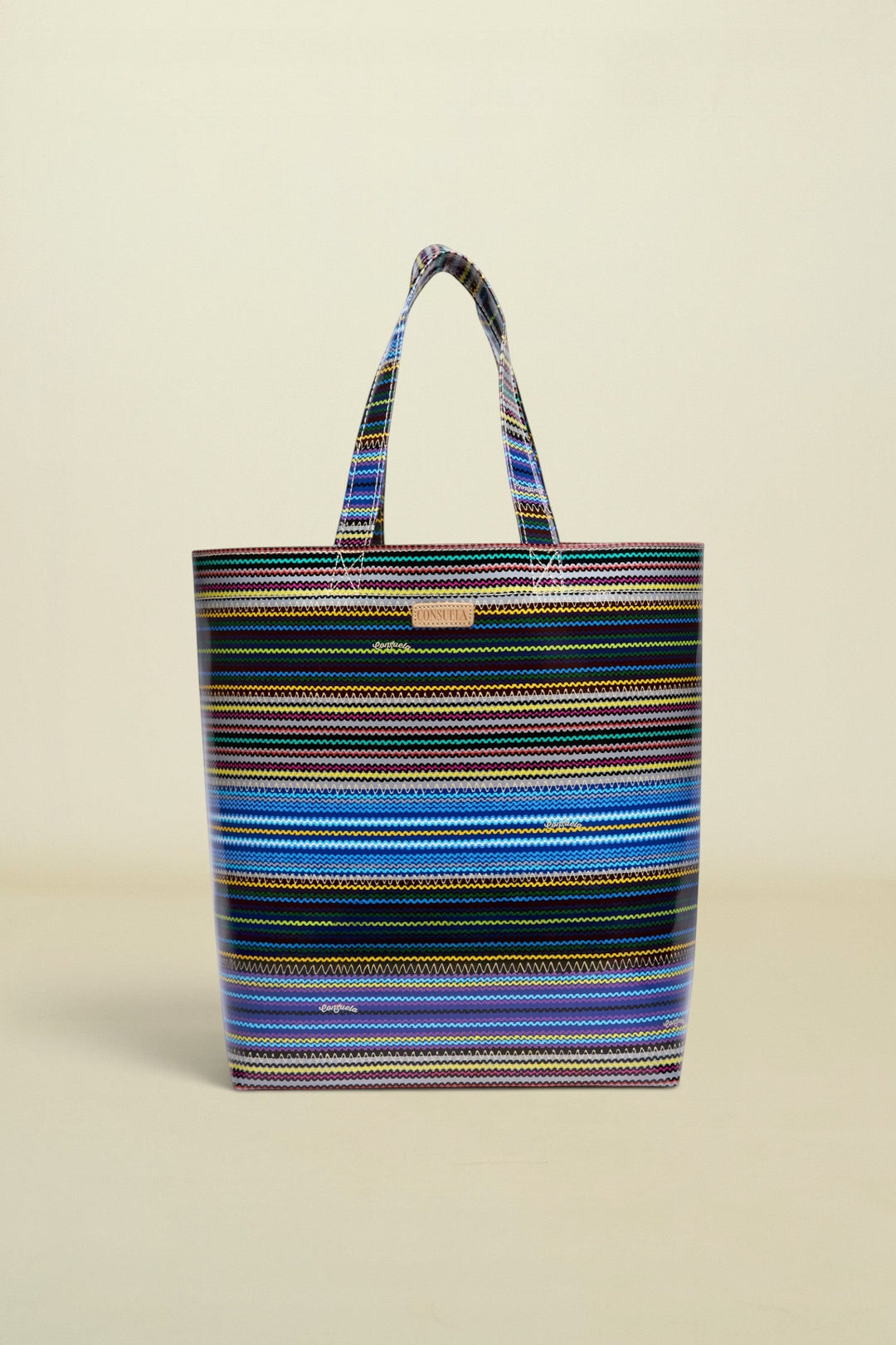 Point of Origin Consuela Hadley basic tote bag featuring a vibrant multi-colored horizontal striped pattern.