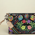 Point of Origin Consuela Rita Uptown crossbody bag in black patent leather with vibrant neon floral embroidery.