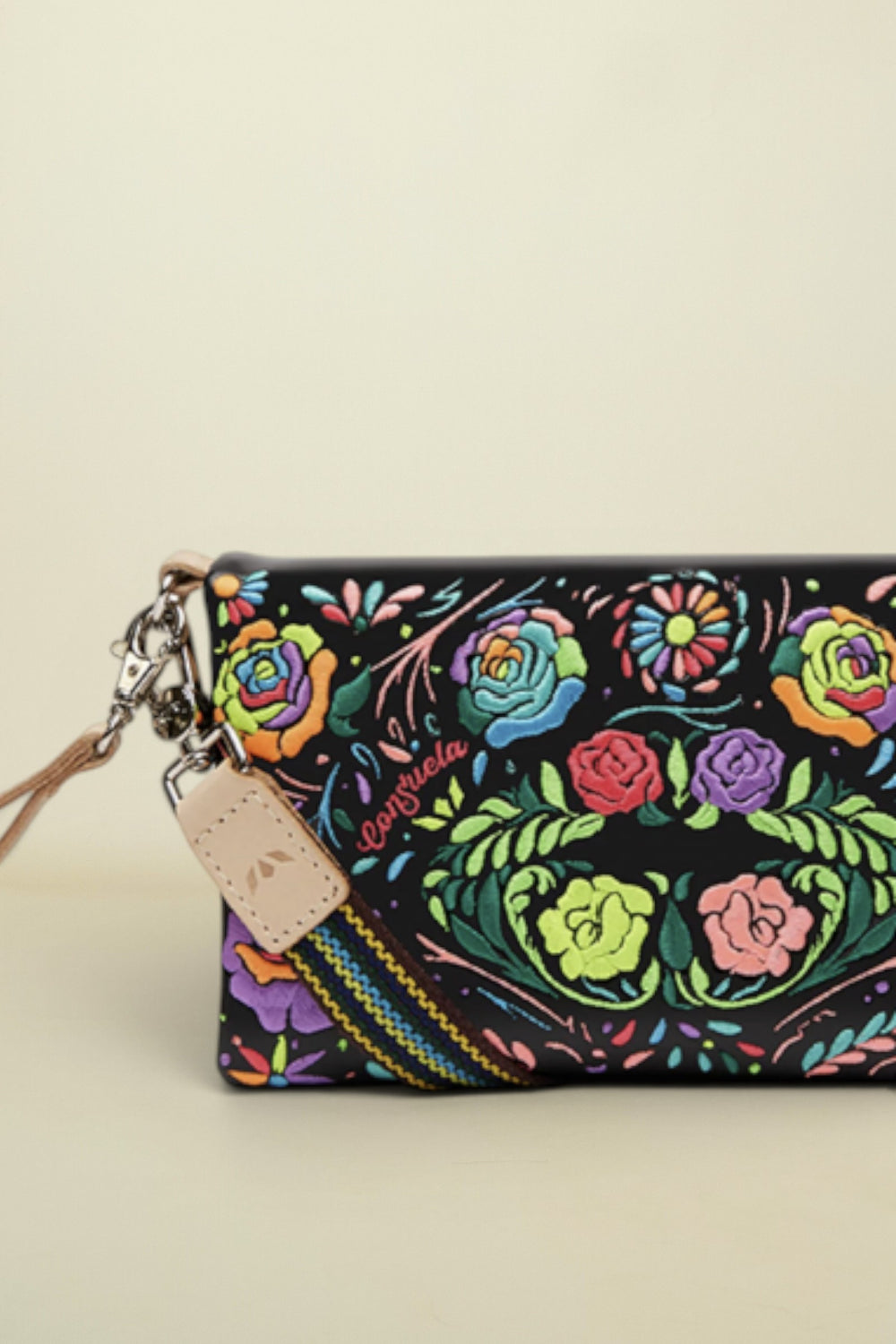 Point of Origin Consuela Rita Uptown crossbody bag in black patent leather with vibrant neon floral embroidery.