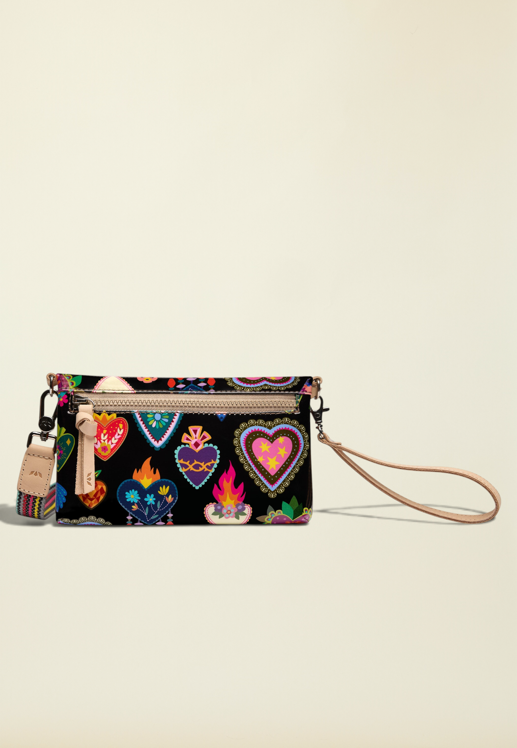 Point of Origin Consuela Vida Uptown crossbody bag in black with colorful heart print and natural leather trim.
