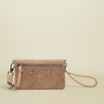 Point of Origin Lawton Uptown crossbody bag in beige leather with intricate floral tooling and a wristlet strap.