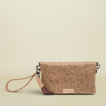 Point of Origin Lawton Uptown crossbody bag in tan embossed leather with a decorative wrist strap.