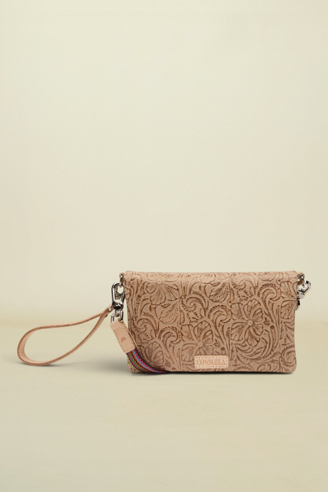 Point of Origin Lawton Uptown crossbody bag in tan embossed leather with a decorative wrist strap.