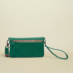 Point of Origin teal leather Uptown crossbody bag with a zippered back pocket and a detachable patterned wrist strap.