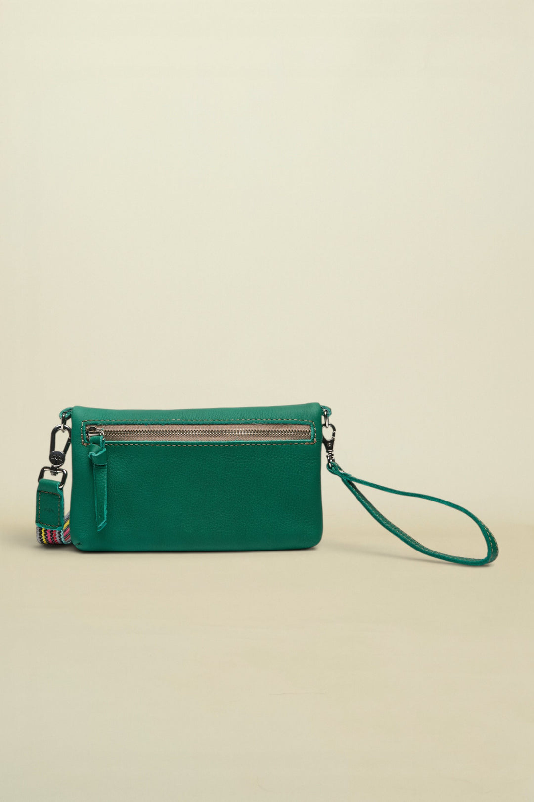 Point of Origin teal leather Uptown crossbody bag with a zippered back pocket and a detachable patterned wrist strap.