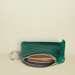 Point of Origin teal leather coin pouch with a silver zipper, key ring, and colorful woven detail