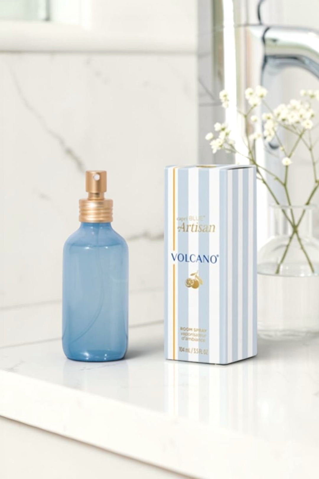 Point of Origin Volcano Caffè Capri room spray in a blue glass bottle with gold sprayer next to its striped box.