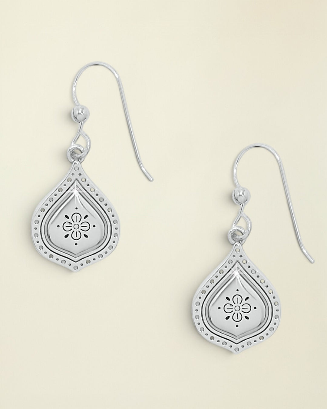 Silver teardrop earrings with floral designs on a white background