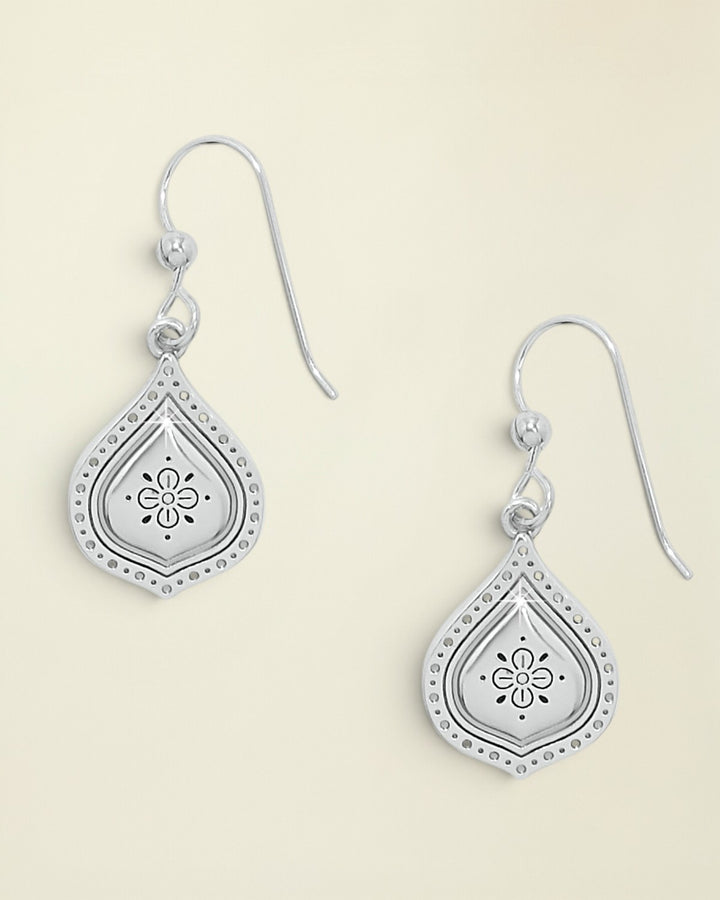 Silver teardrop earrings with floral designs on a white background