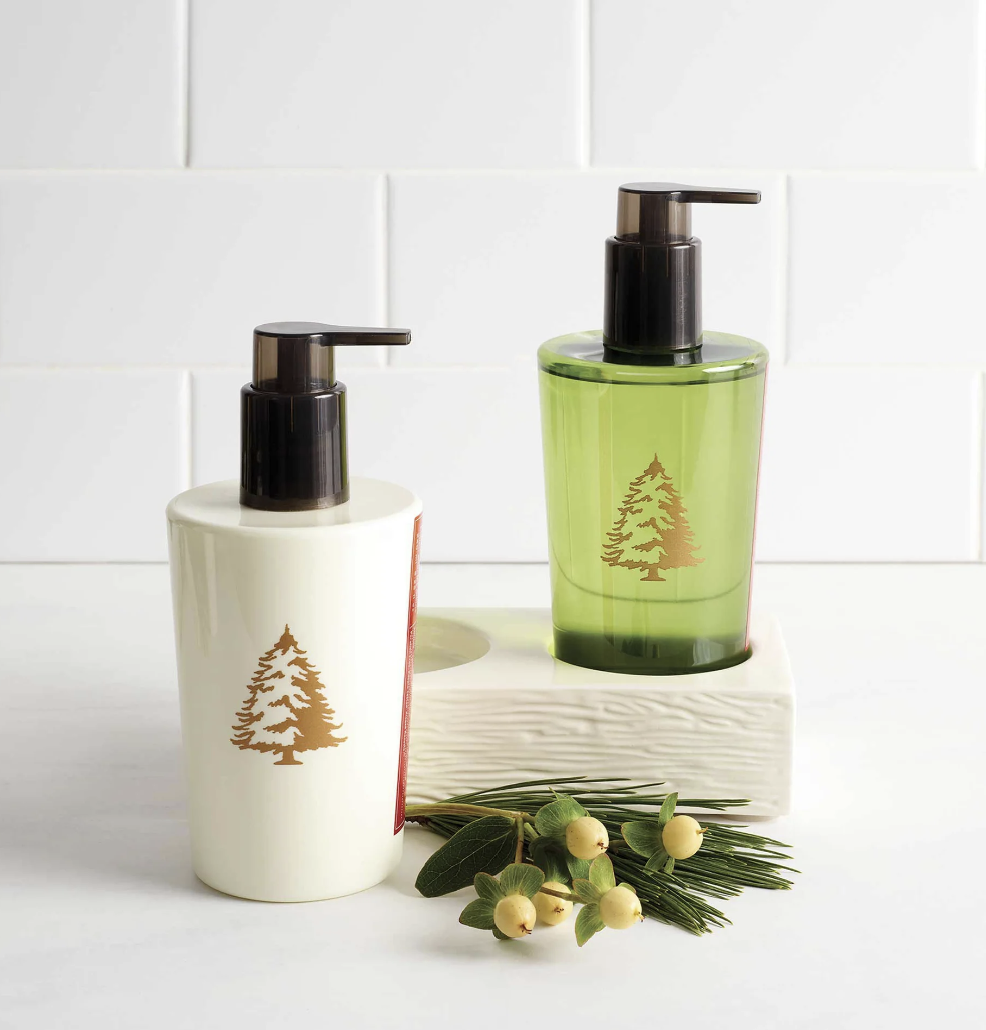 Two soap dispensers, one white and one green, with tree designs on a white background.