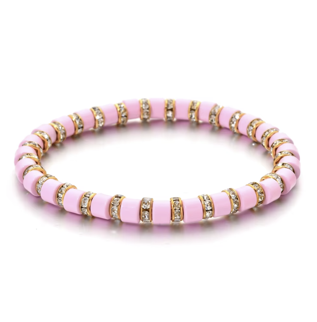 Pink beaded bracelet with gold accents on a white background