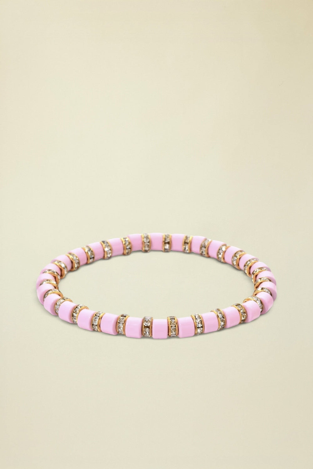 Pink beaded bracelet with gold accents on a white background