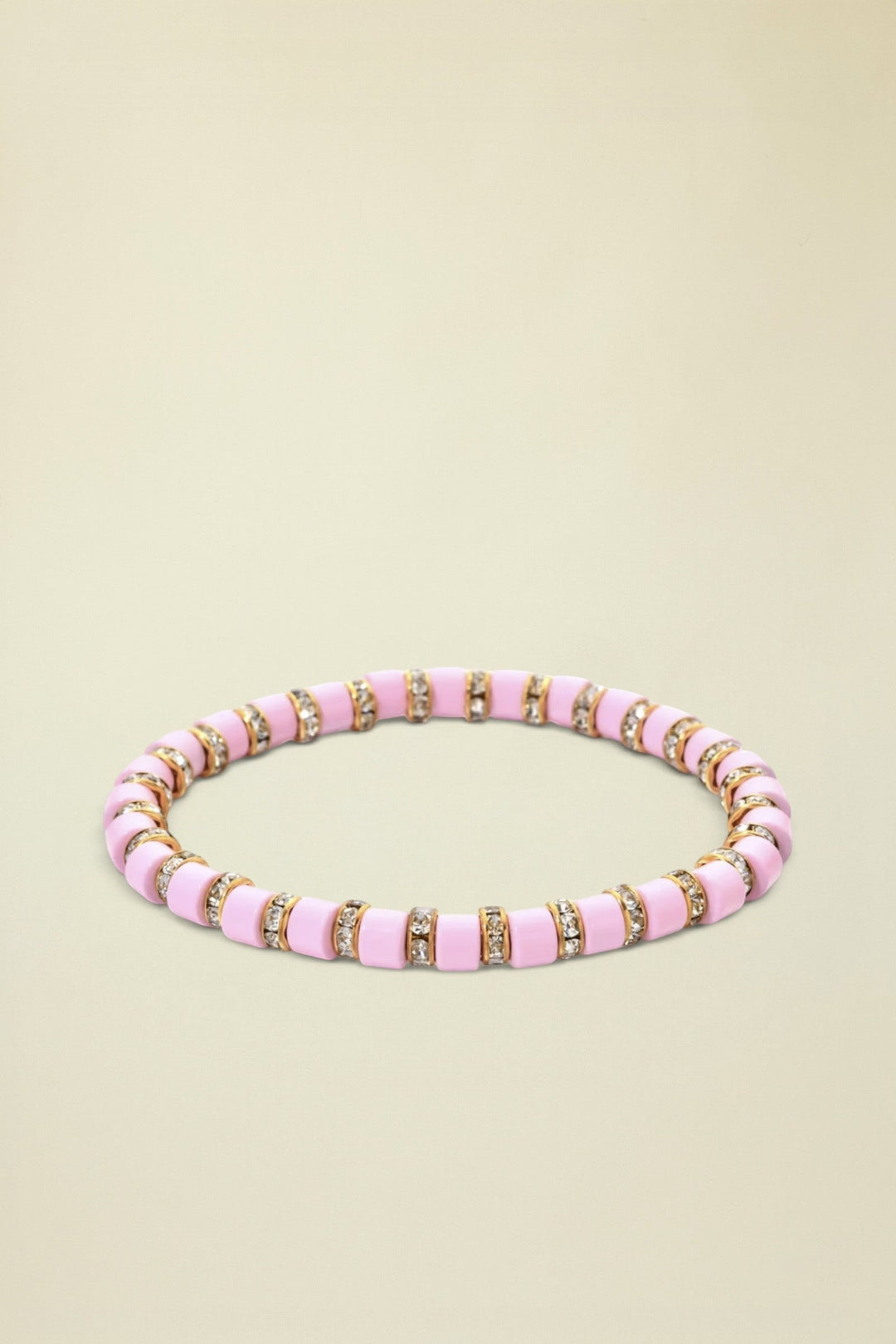 Pink beaded bracelet with gold accents on a white background