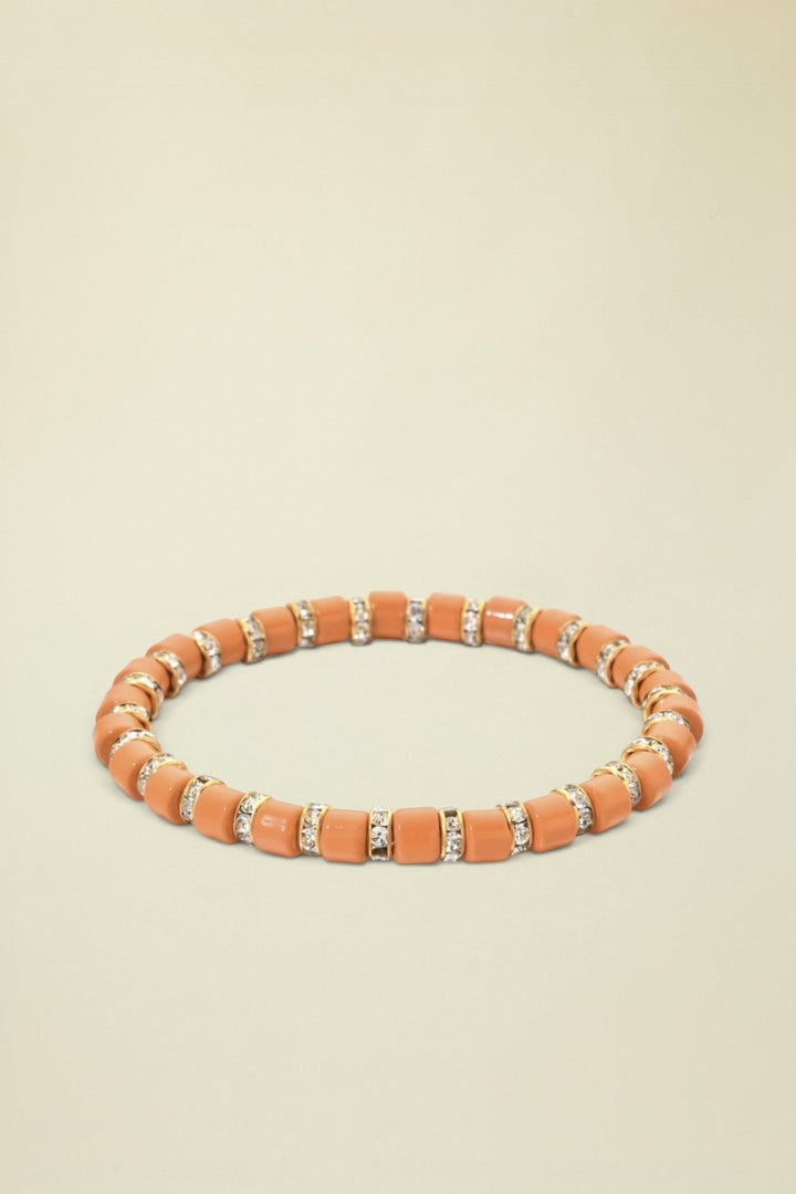 Orange beaded bracelet with small crystals on a white background