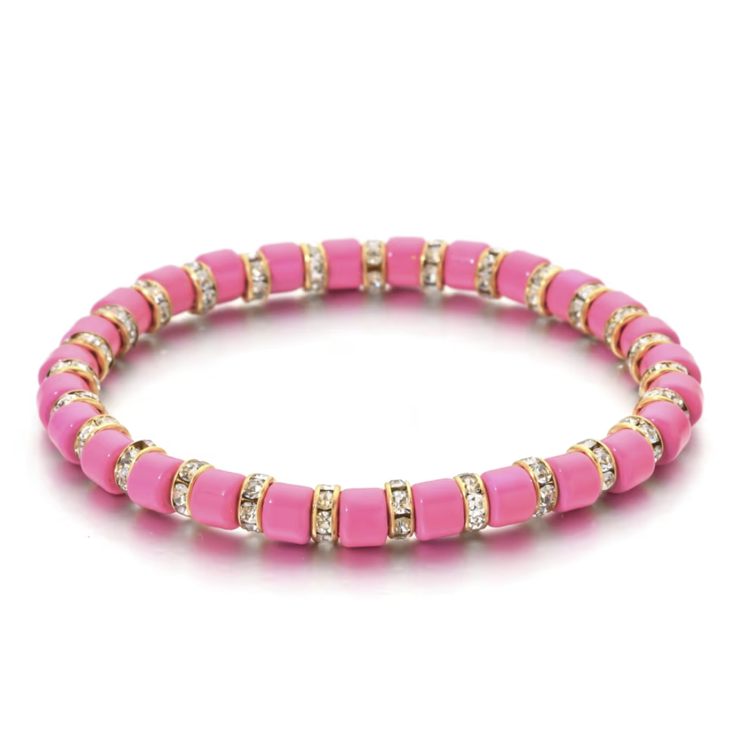 Pink beaded bracelet with gold and clear accents on a white background
