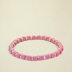 Pink beaded bracelet with gold and clear accents on a white background