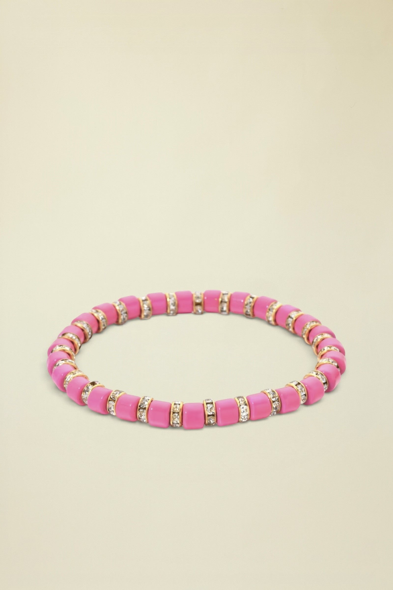 Pink beaded bracelet with gold and clear accents on a white background