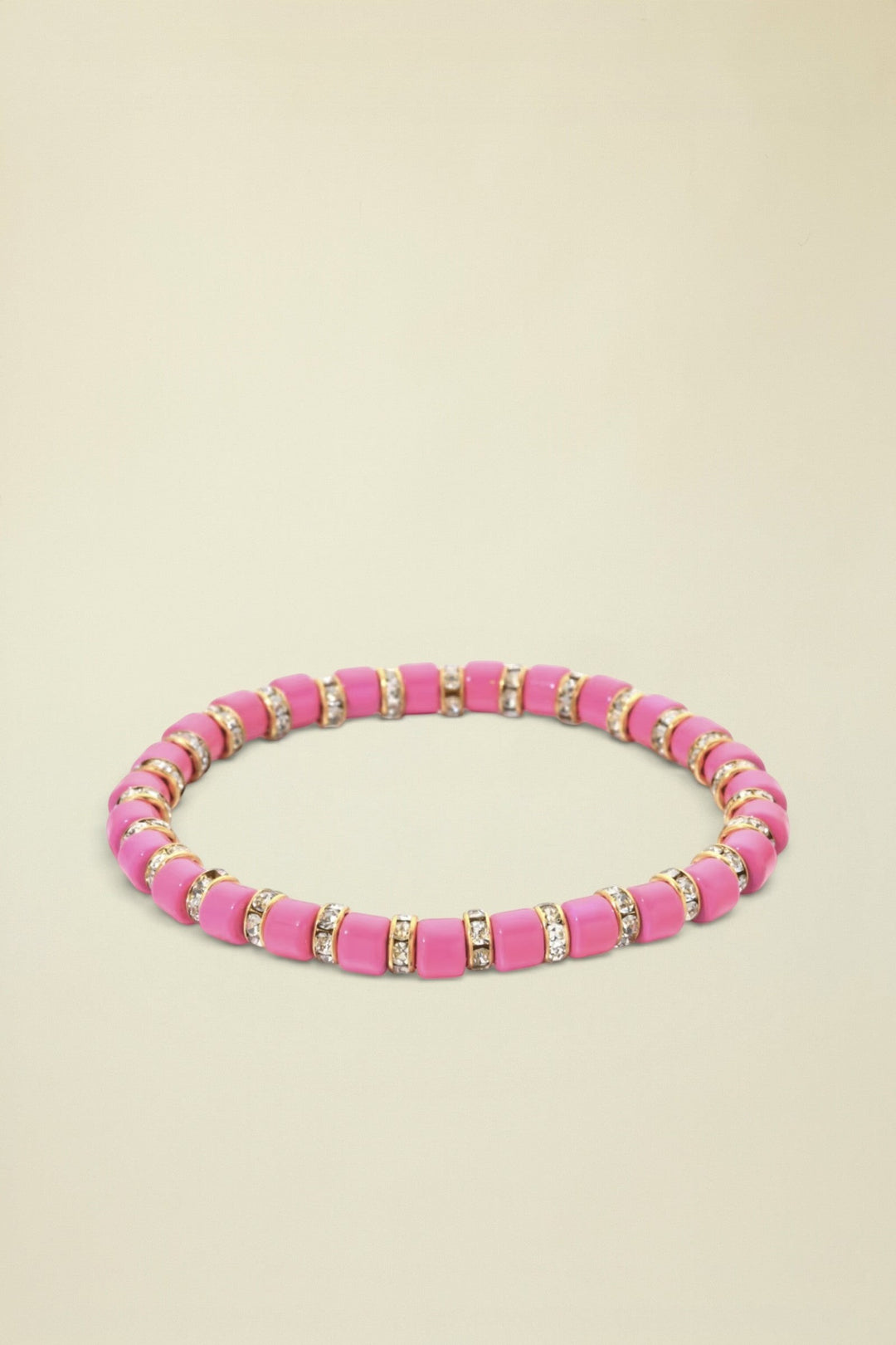 Pink beaded bracelet with gold and clear accents on a white background
