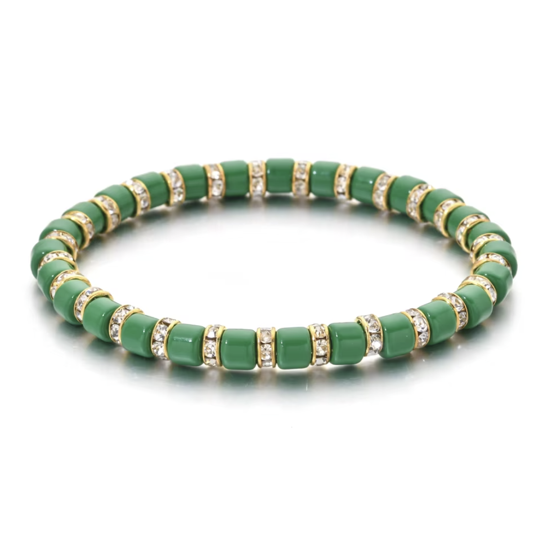 Green beaded bracelet with gold accents on a white background