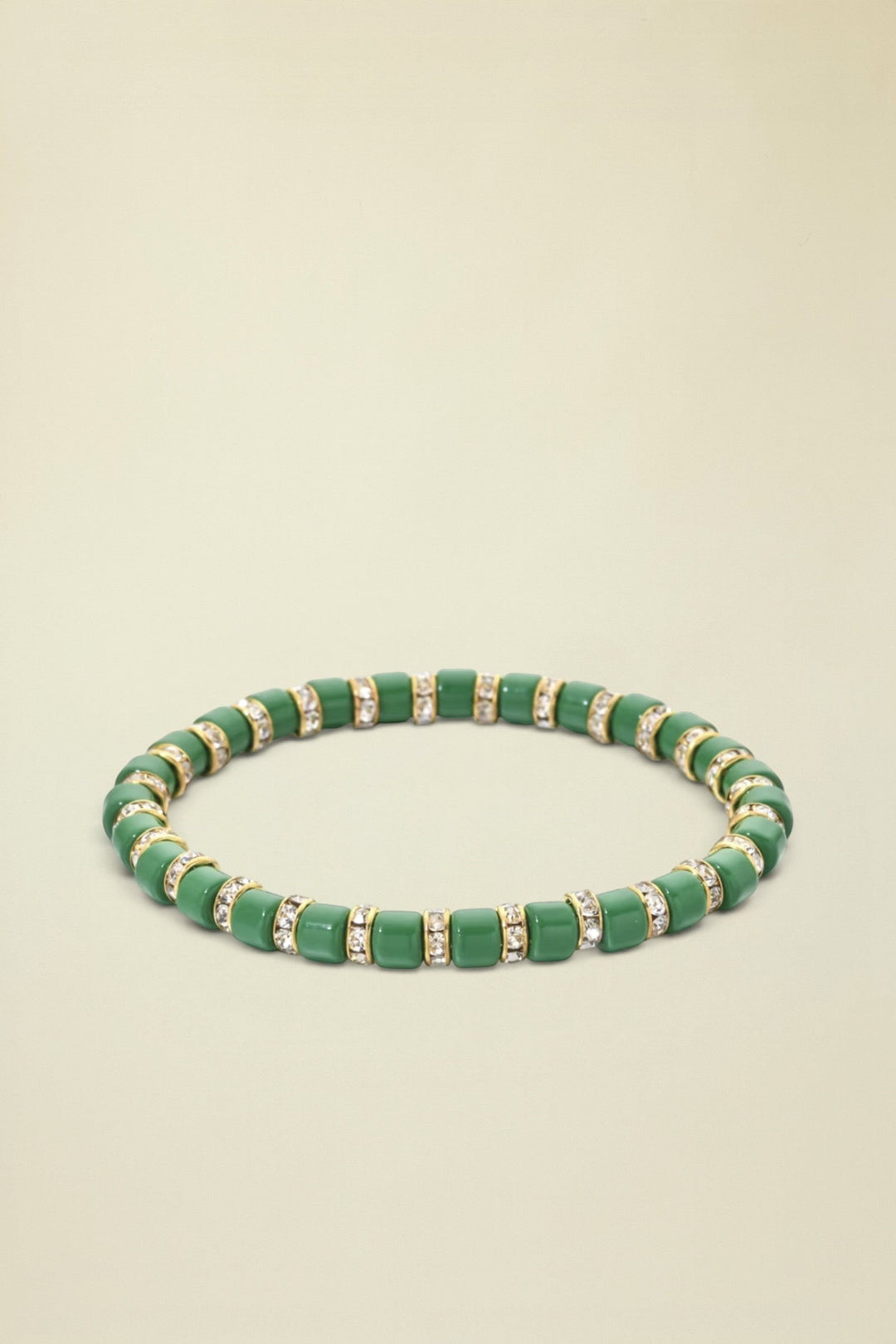 Green beaded bracelet with gold accents on a white background