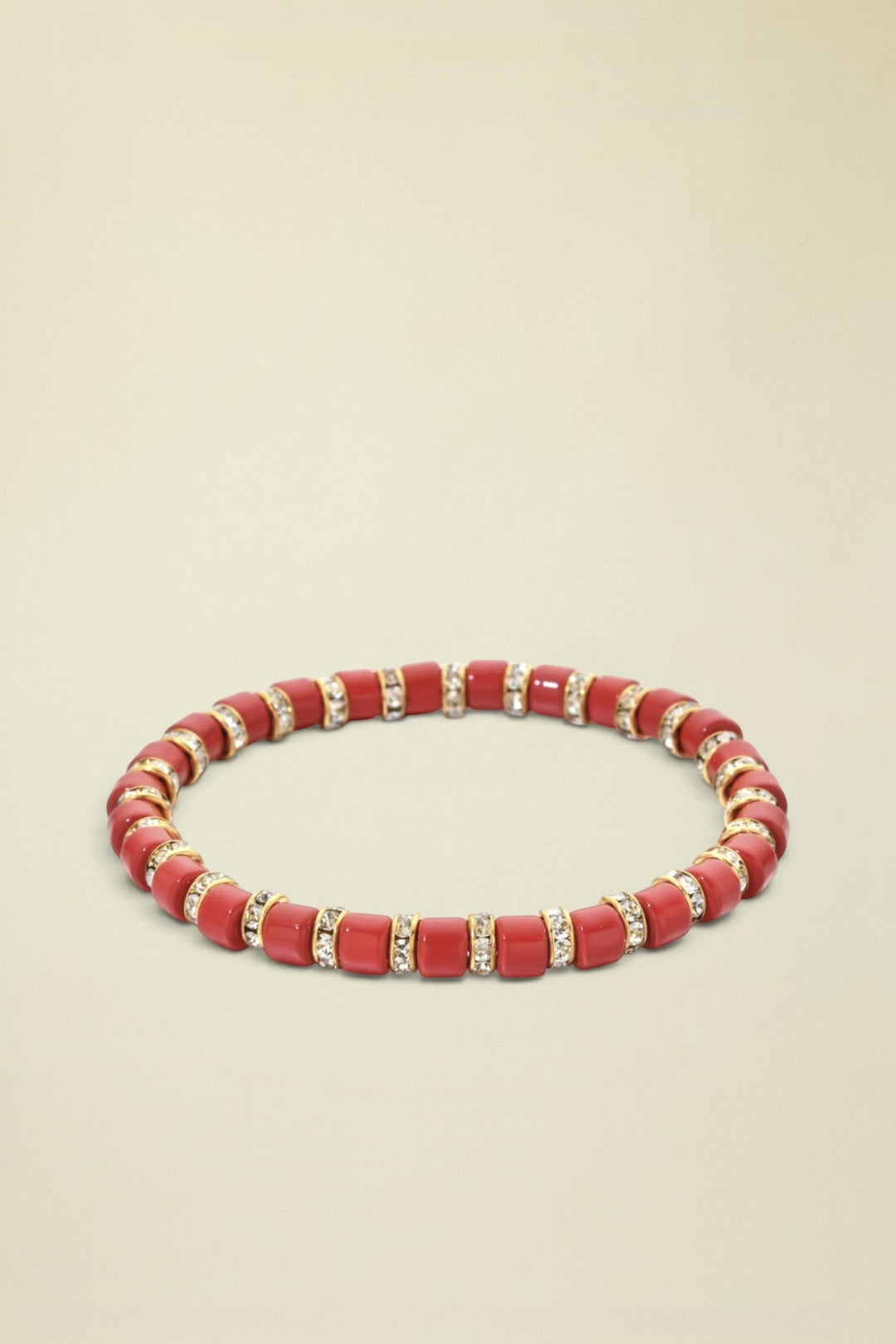 Red beaded bracelet with gold accents on a white background