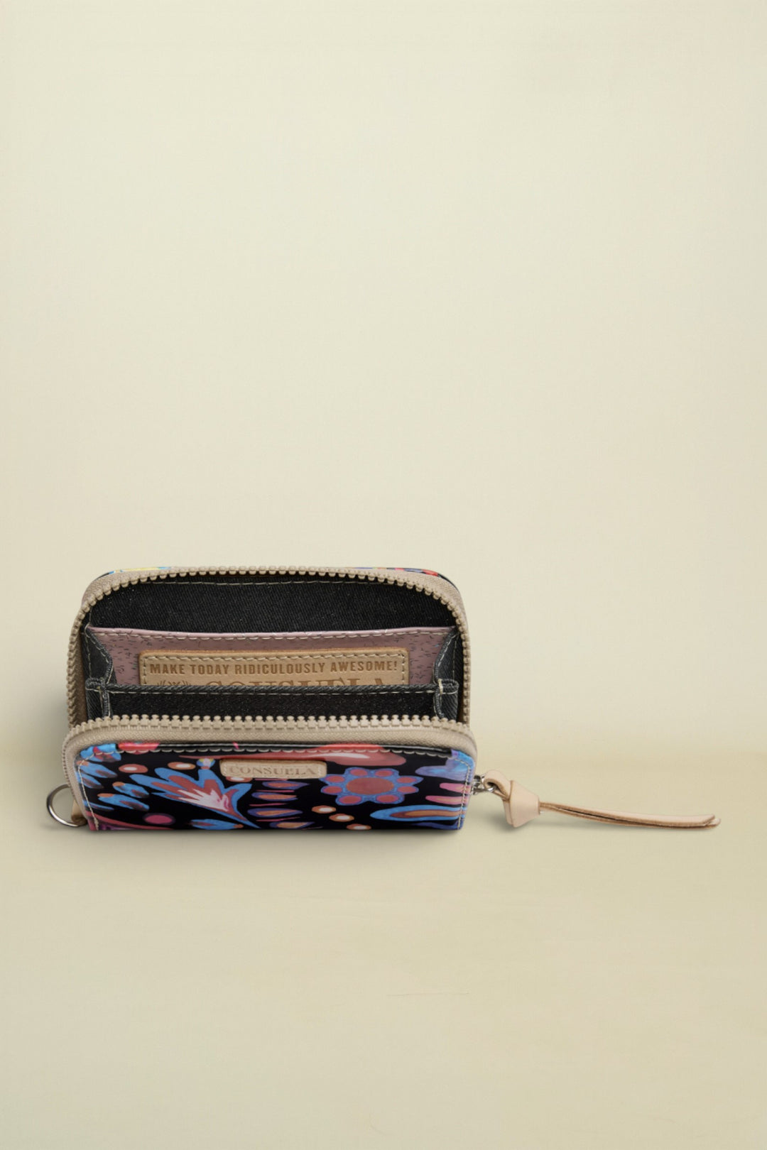 Small wallet with floral pattern and visible brand name on a white background